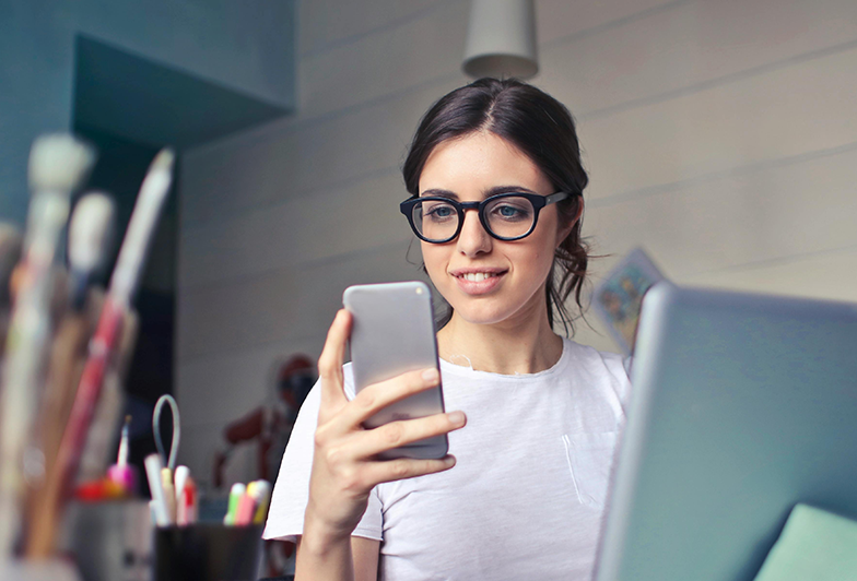 woman uses her phone to access investment apps